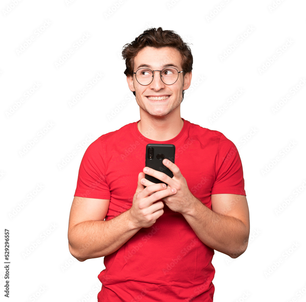 Happy young man looking up and using a mobile phone Happy young man looking up and using a mobile phone
