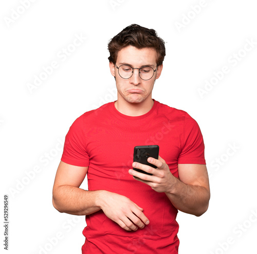 Sad young man using a mobile phone