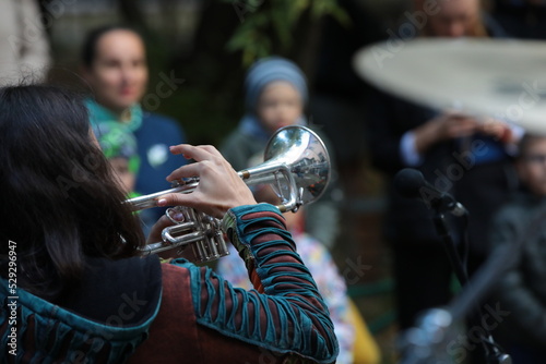 A woman playing the trumpet to the public at a national holiday.The concept of recreation and entertainment of people