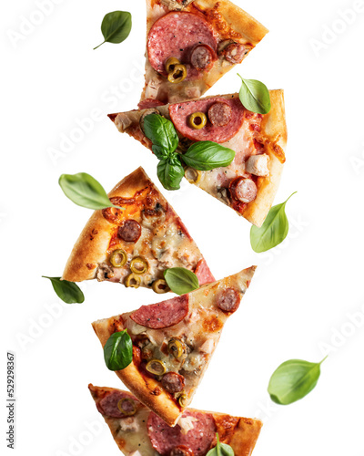 Pizza with salami, bazil leaves and vegetables in levitation