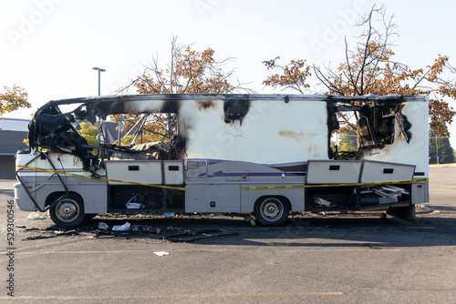 Burned out RV motorhome interior after a fire or explosion or fire bomb or arson shows the melted interior and the devastation of the accident.  Yellow caution tape,
