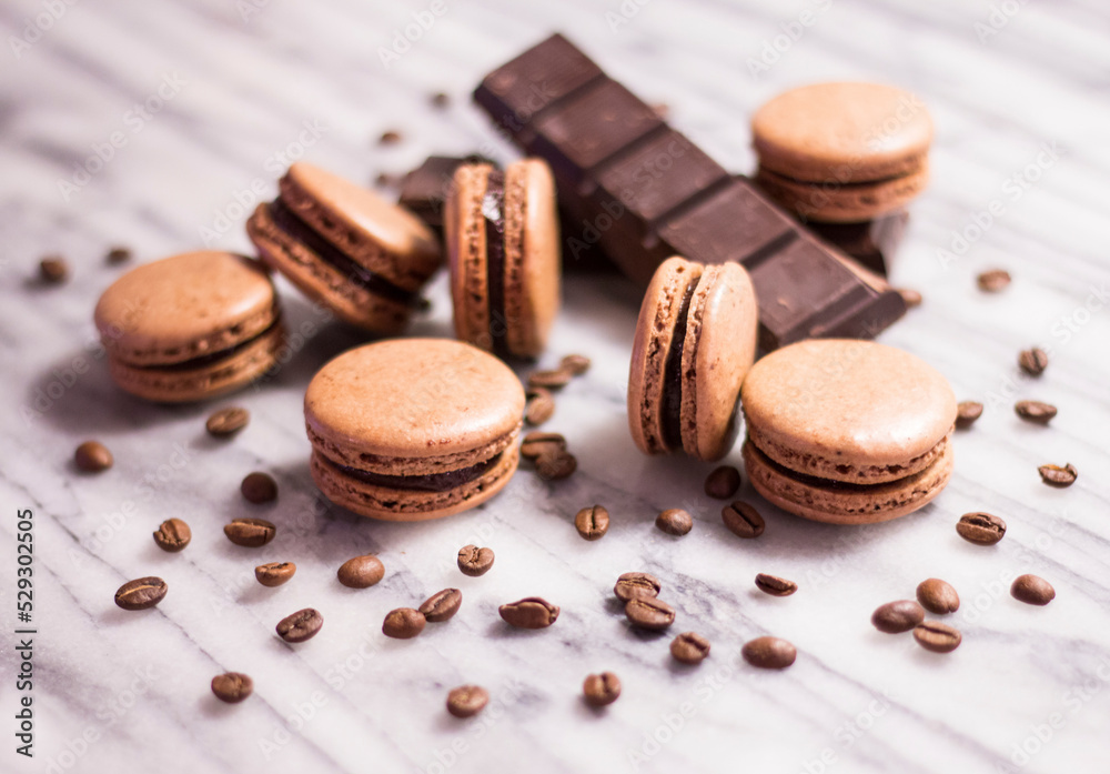 Close-up of macaroons with chocolate bar and coffee beans on table Close-up of macaroons with chocolate bar and coffee beans on table