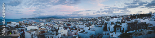 Panoramic view of cityscape against cloudy sky during sunset photo