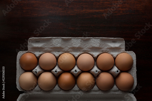 Overhead view of brown eggs in carton on table photo