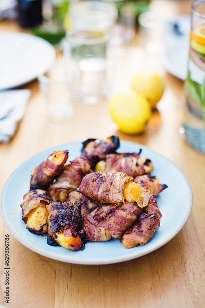 High angle view of bacons with nectarines served in plate on wooden table High angle view of bacons with nectarines served in plate on wooden table