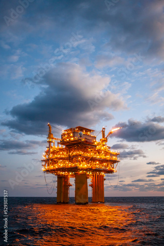 Illuminated oil exploration platform in sea against cloudy sky photo