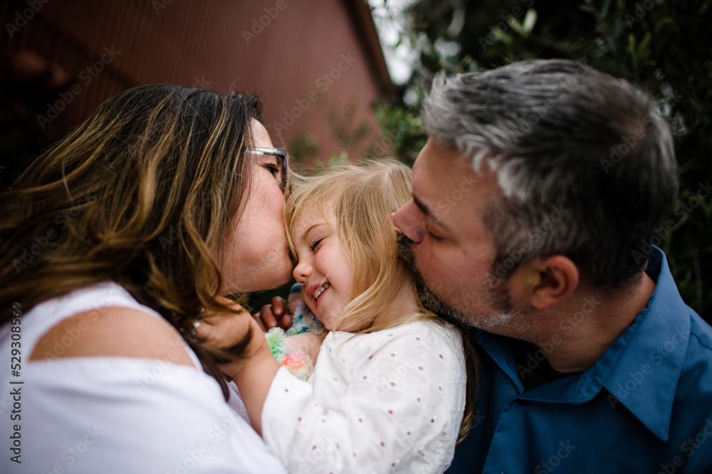 Close-up of parents kissing daughter at tourist resort Close-up of parents kissing daughter at tourist resort