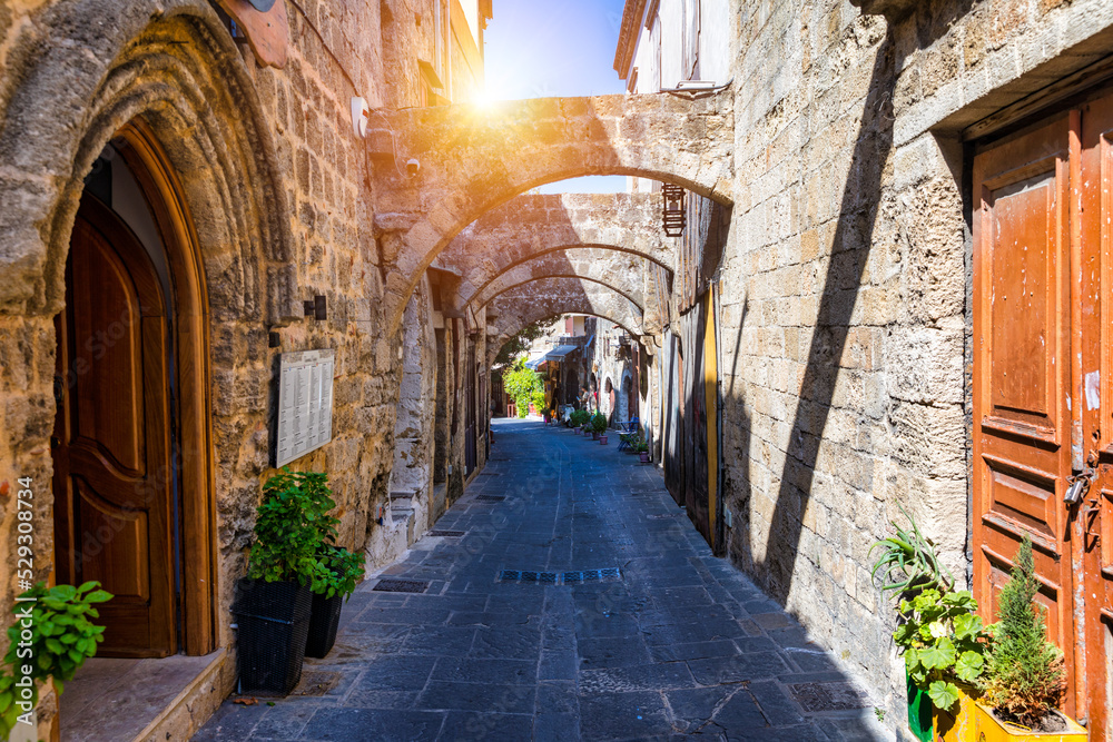 Medieval arched street in the old town of Rhodes, Greece. Rhodes old town in Rhodes island in Greece. Historical streets of old town Rhodes with flowers in Rhodes, Dodecanese, Greece