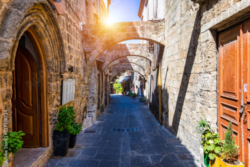 Medieval arched street in the old town of Rhodes  Greece. Rhodes old town in Rhodes island in Greece. Historical streets of old town Rhodes with flowers in Rhodes  Dodecanese  Greece