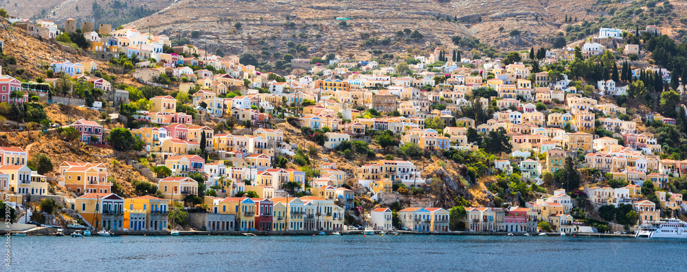 View of the beautiful greek island of Symi (Simi) with colourful houses and small boats. Greece, Symi island, view of the town of Symi (near Rhodes), Dodecanese.
