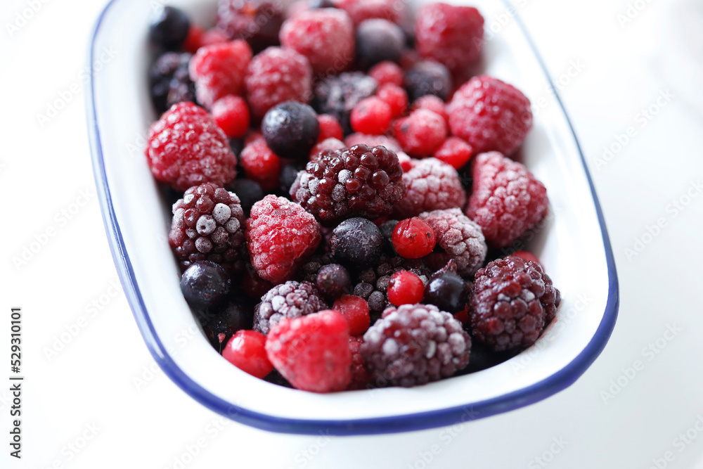 Close-up of frozen berries in bowl over white background Close-up of frozen berries in bowl over white background