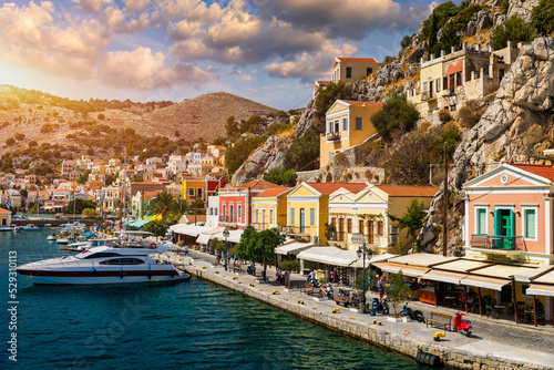 View on Symi (Simi) island harbor port, classical ship yachts, houses on island hills, Aegean Sea bay. Greece islands holidays vacation travel tours from Rhodos island. Symi, Greece, Dodecanese.