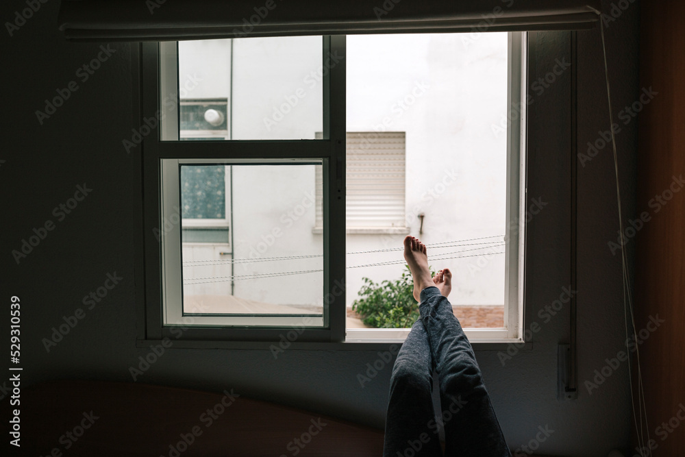 Low section of teenage girl resting legs on window sill in bedroom Low section of teenage girl resting legs on window sill in bedroom