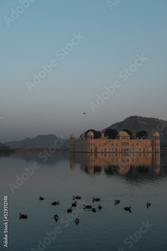Jal Mahal with ducks swimming in lake against sky during sunset photo