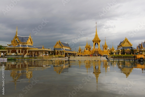 Royal crematorium reflecting on water against cloudy sky photo