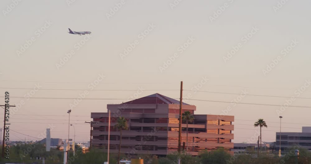 Airplane taking off over Scottsdale, Arizona during purple sunset in real time