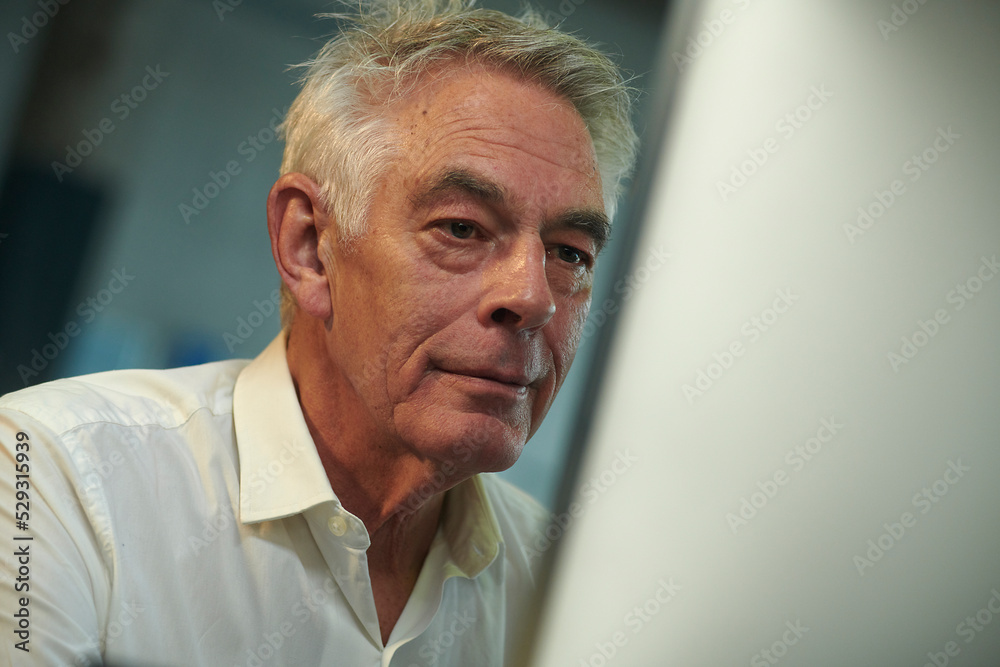 Close-up of confident businessman using desktop computer in office Close-up of confident businessman using desktop computer in office