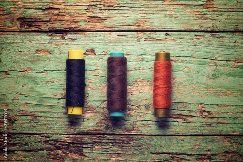 Overhead view of colorful threads on old wooden table photo