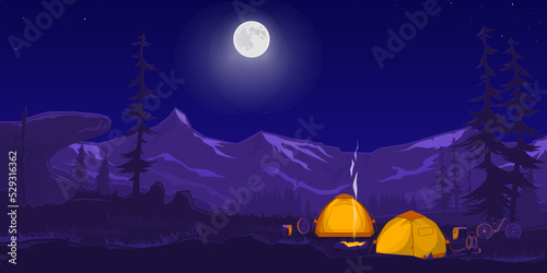 Panoramic night view of the tourist camp. The bright moon illuminates the mountains, coniferous forest, rocky cliff, foothill plain. Tents, campfire, bicycles, camping refrigerator, food box, backpack