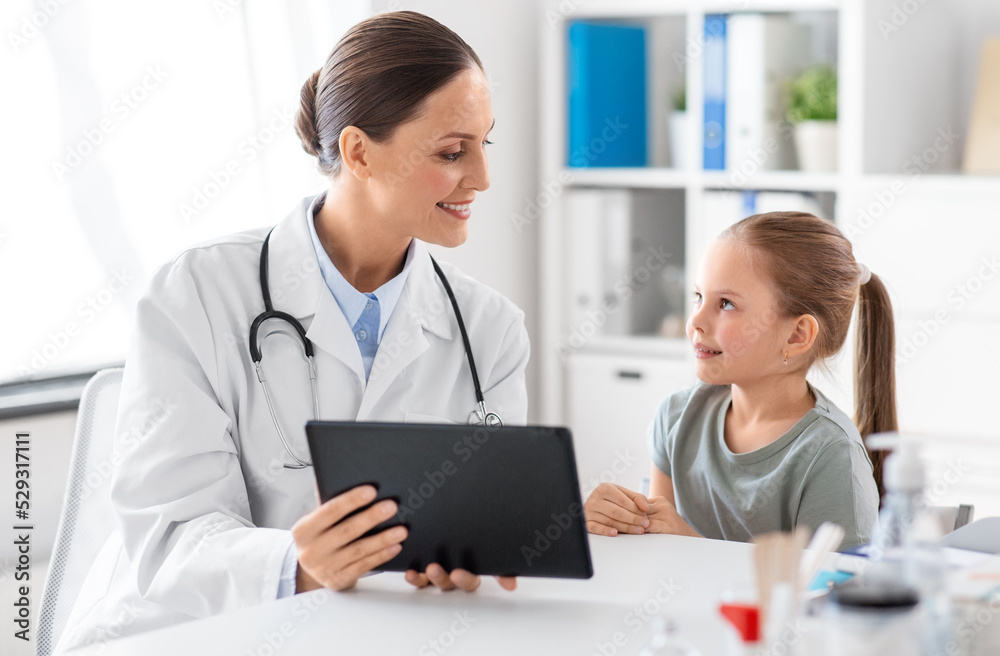 medicine, healthcare and pediatry concept - happy smiling female doctor or pediatrician showing tablet computer and talking to little girl patient at clinic medicine, healthcare and pediatry concept - happy smiling female doctor or pediatrician showing tablet computer and talking to little girl patient at clinic