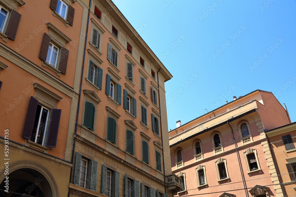 Low angle view of buildings against clear blue sky in Bologna city