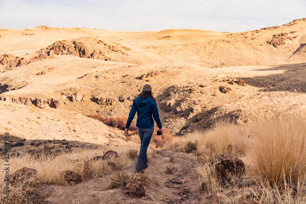 Woman hiking on dirt path in dry landscape Woman hiking on dirt path in dry landscape