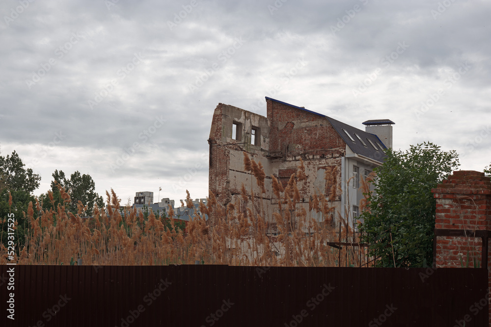 Ruins in city. Half destroyed building behind the fence, copyspace
