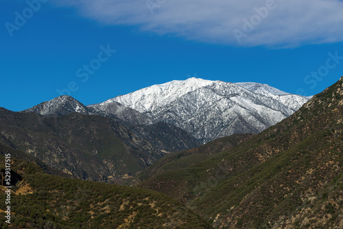 Angeles National Forest including snowcapped Mount San Antonio or Mount Baldy against a blue sky.