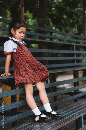 Girl in school uniform standing on iron stairs photo