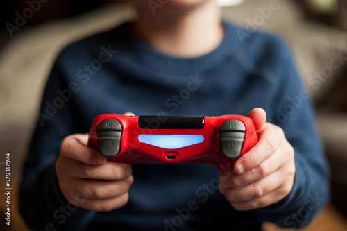 Young boy playing with video game controller while playing video game photo