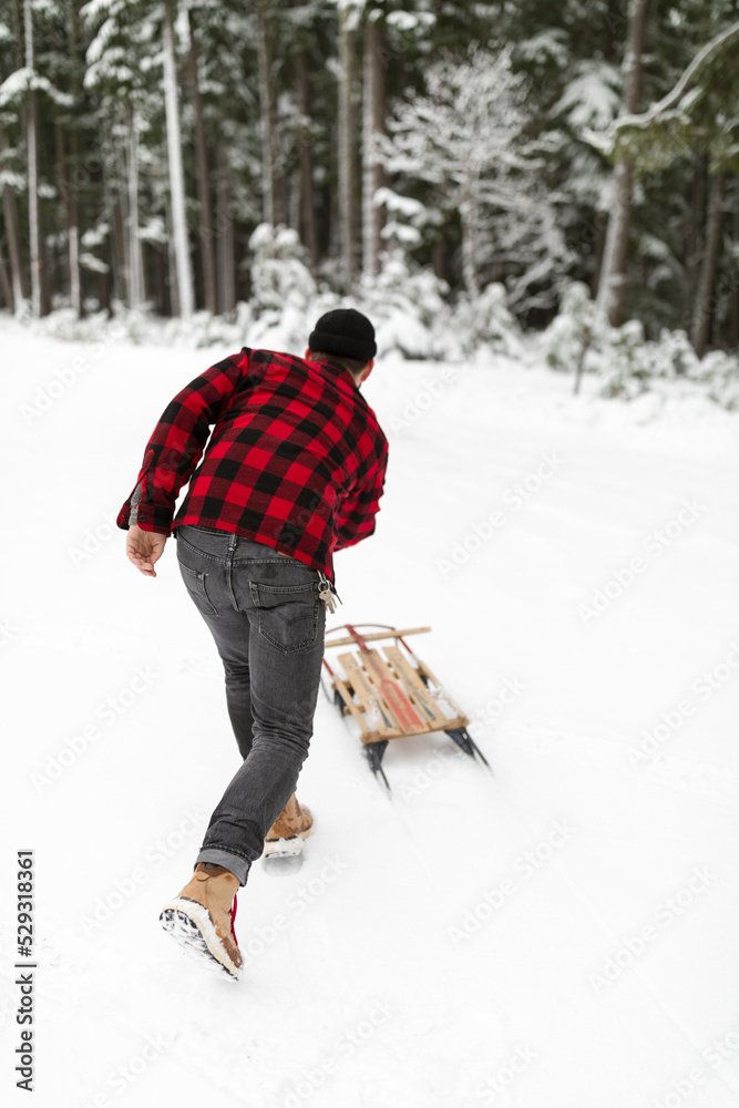 Man pushing sled across snow Man pushing sled across snow