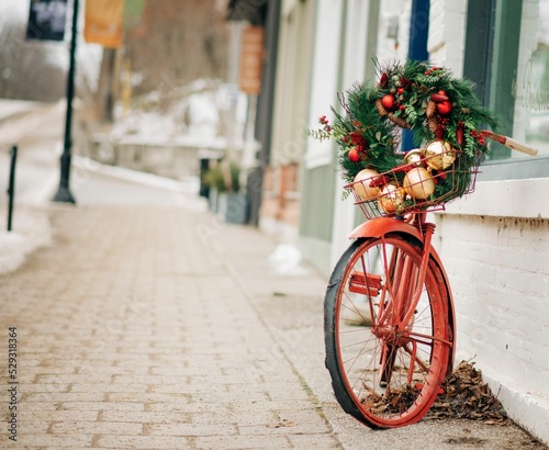 Christmas wreath on a bike with a basket on path in a town photo