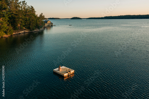 Woman On A Dock On A Lake In Muskoka Canada At Sunset photo