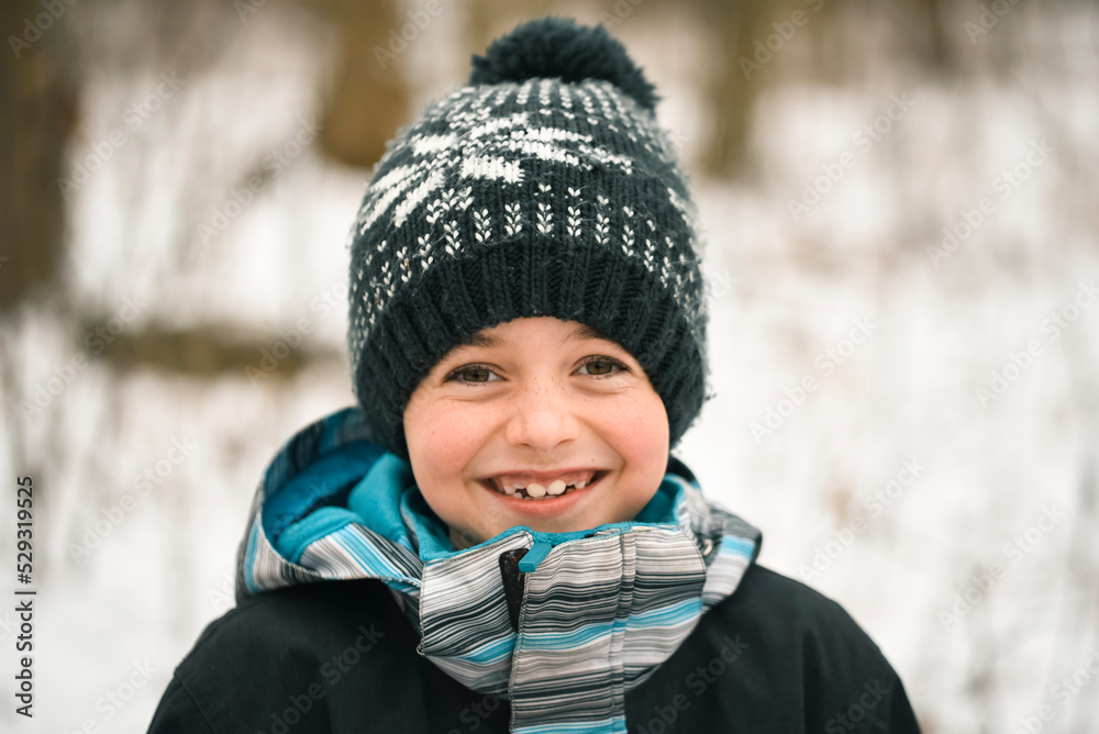 Close up of smiling young boy outside in winter wearing clothing. Close up of smiling young boy outside in winter wearing clothing.