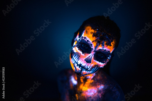 Girl's face painted UV skull