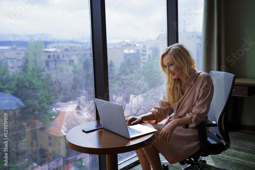 Businesswoman using laptop while working at the office