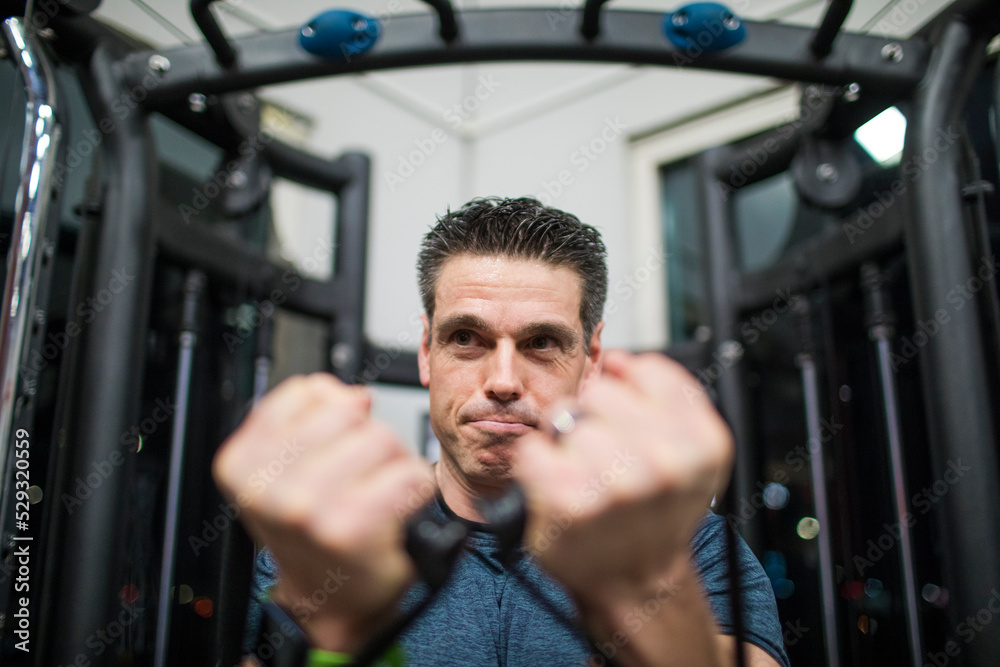 Athletic man trains his pectoral muscles at the gym Athletic man trains his pectoral muscles at the gym
