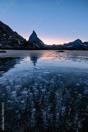 Matterhorn mirrored in Riffelsee covered of ice bubbles photo