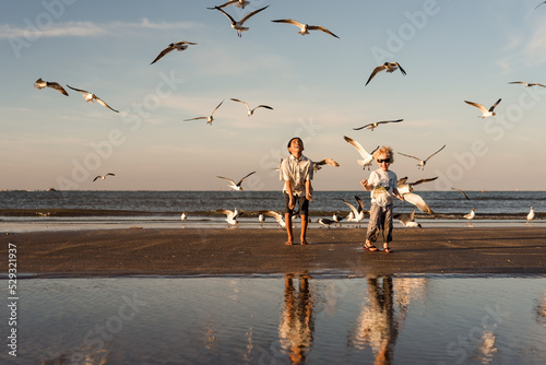 Two siblings playing with birds on Galveston Island photo