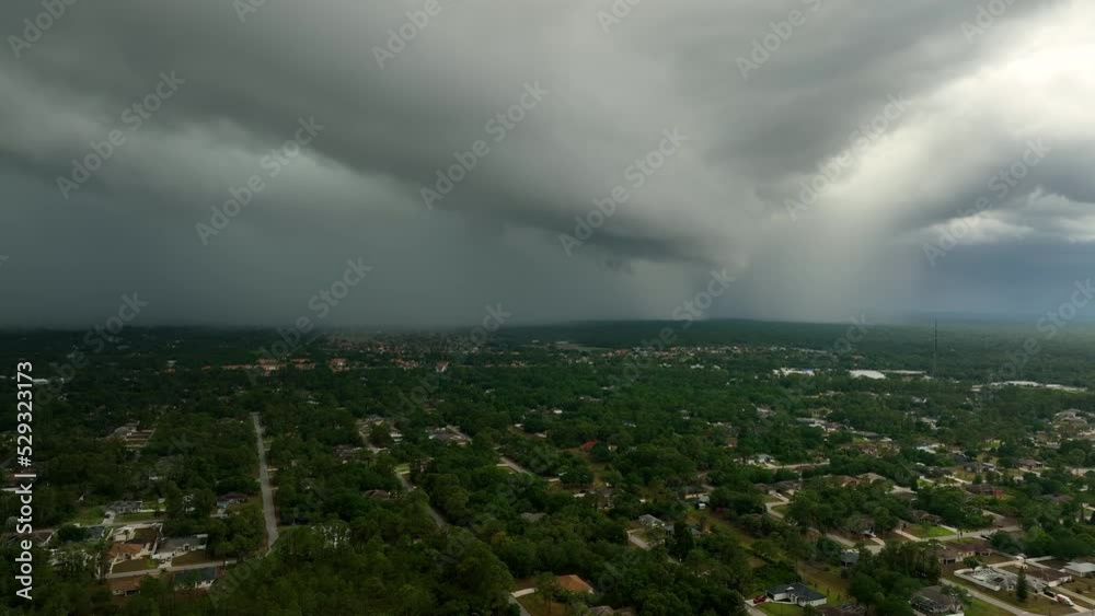 Landscape of dark ominous clouds forming on stormy sky before heavy thunderstorm over rural town area Landscape of dark ominous clouds forming on stormy sky before heavy thunderstorm over rural town area