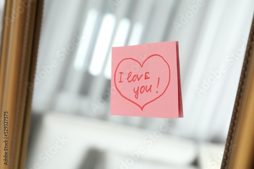 Note with phrase I Love You attached to mirror