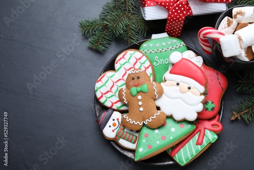 Delicious gingerbread Christmas cookies on black table, flat lay. Space for text