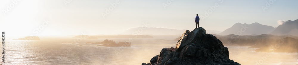 Adventurous Man Hiking on the Rocky Coast with Mountains and Dramatic Sunset Sky. Adventure Composite. 3d Rendering Rocks. Background from West Coast of British Columbia, Canada.