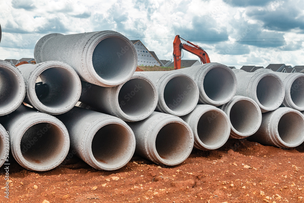 new concrete pipes stacked on a construction site. Preparation for the manufacture of the sewer system. new concrete pipes stacked on a construction site. Preparation for the manufacture of the sewer system.
