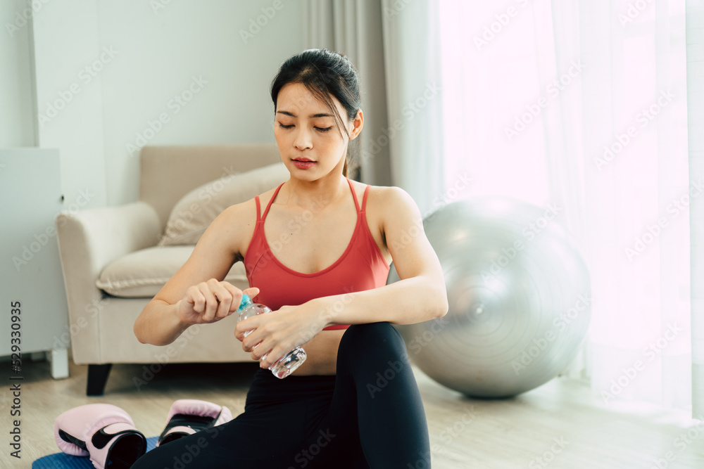 Asian woman in yoga sportswear sitting on the mat and open drinking water after practicing yoga. Asian woman in yoga sportswear sitting on the mat and open drinking water after practicing yoga.