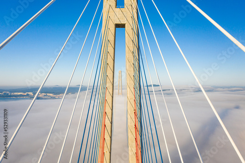 Drone flight over the support of the bridge built across the sea strait at dawn © MikeDrone