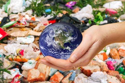 Fototapeta Naklejka Na Ścianę i Meble -  Defocus female hand holding planet globe on garbage background. Environmental protection concept. Earth in hands. Save of Earth. Elements of this image furnished by NASA. Out of focus