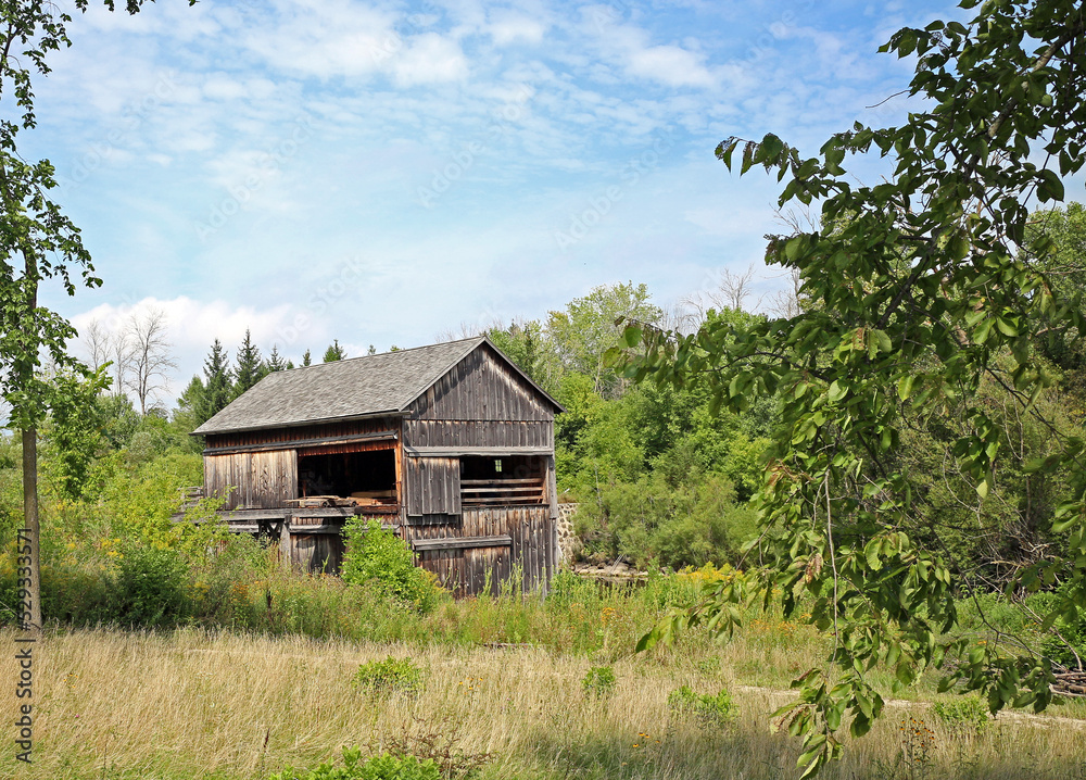 Old Sawmill Wooden Building in country, partly clouded sky with trees. Old Sawmill Wooden Building in country, partly clouded sky with trees.