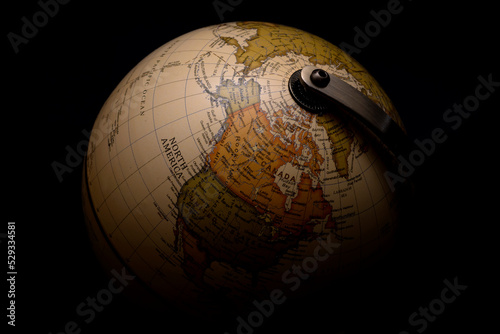 Obraz na płótnie Moody picture of antique spinning globe model surrounded by darkness concept for menacing shadows covering the world, worldwide worry about the future of planet earth and global conflict w salonie