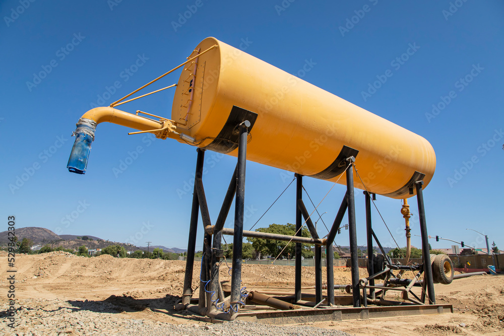 Yellow water tank at a construction site Yellow water tank at a construction site